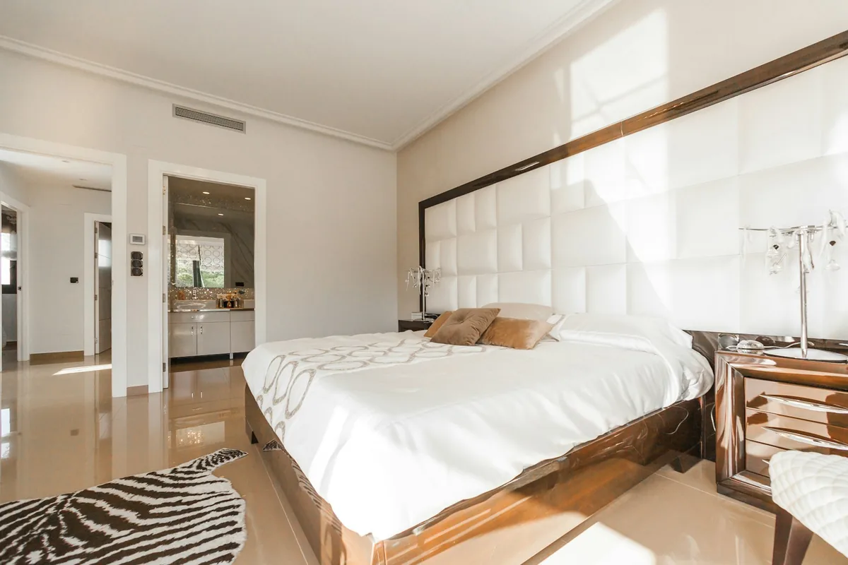 Serene and uncluttered bedroom interior with organized linen bedding and warm daylight creating a calm sanctuary