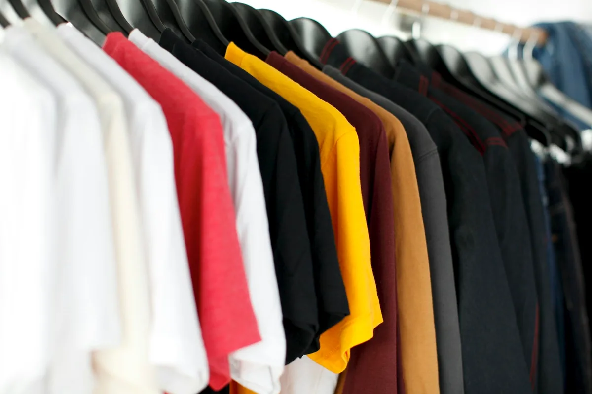 Conscious living aesthetic showing a capsule collection of durable natural linen clothing on wooden hangers